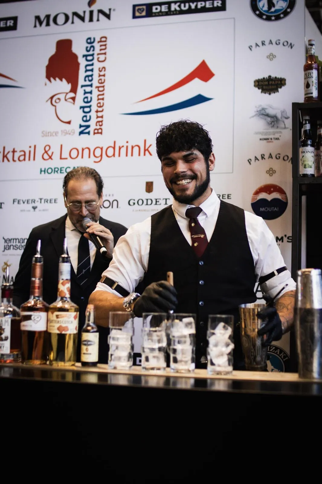 Cedric lacht naar de camera bij de bar